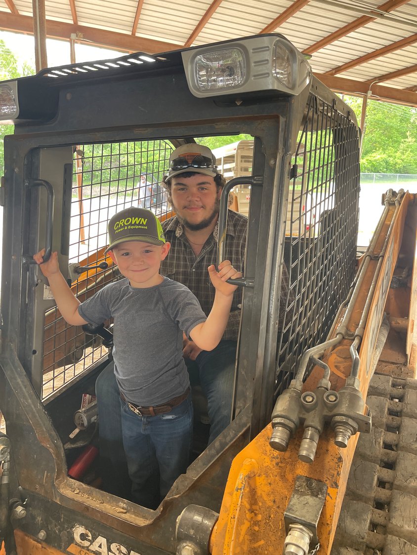 Five-year-old Gus Wrinkle watches the weigh-ins with his big brother Thomas, 16, from a skidsteer.